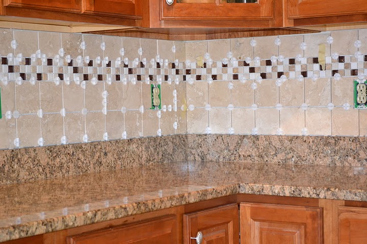 Freshly tiled kitchen backsplash with spacers still installed.